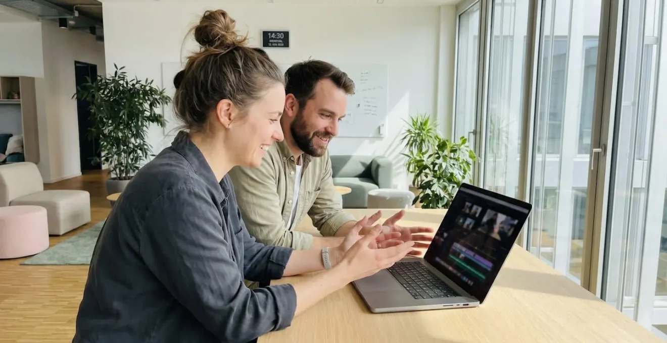 Nahaufnahme von Händen auf einer modernen Tastatur, im Hintergrund ist eine unscharfe Video-Timeline-Oberfläche auf einem Bildschirm erkennbar